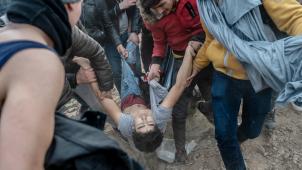<p>Migranten helfen einem verletzten Mann ander griechisch-türkischen Grenze in Edirne.</p>
