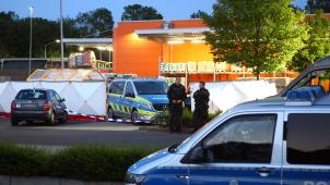 <p>Polizisten stehen am Tatort auf dem Parkplatz des Baumarkts.</p>