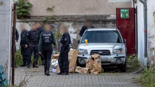 <p>Polizisten stehen in einem Hinterhof in der Duisburger Innenstadt, auf dem Boden stehen Papiertüten mit Beweismitteln.</p>