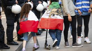 <p>Zwei Kinder auf Kickrollern tragen am Rande einer Demonstration anlässlich des Todestages von Jina Mahsa Amini Flaggen des Iran. Jina Mahsa Amini kam im September 2022 im Iran nach einer Festnahme durch die berüchtigten Sittenwächter im Polizeigewahrsam ums Leben. Ihr Tod löste die heftigsten Proteste in der Islamischen Republik seit Jahrzehnten aus.</p>