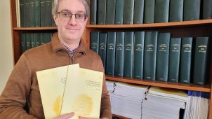 <p>Cédric Istasse mit seiner Schrift über die DG, die ihn drei Jahre in Anspruch nahm.</p>