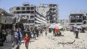 <p>Menschen stehen inmitten von Trümmern im Flüchtlingslager Jabalia im Norden des Gazastreifens.</p>