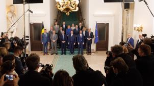 <p>Die erste Gruppenfoto der neuen Föderalregierung am Montag wurde kritisiert, da die wenigen Ministerinnen kaum zu sehen waren. Von den 14 Regierungsmitgliedern sind nur vier Frauen, was die Debatte über eine gerechtere Geschlechterverteilung im Kabinett neu entfacht hat. Die Grünen fordern eine gesetzliche Mindestquote für Frauen in der Regierung. Besonders kritisiert wird, dass der engere Führungskreis ausschließlich aus Männern besteht. Nach der Kritik veröffentlichte die Regierung am nächsten Tag ein neues, besser ausgeleuchtetes Gruppenfoto.</p>