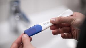<p>Eine Frau hält einen positiven Schwangerschaftstest in den Händen.</p>