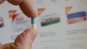 <p>Eine Arzneikapsel vor einem Bildschirm mit dem Angebot einer Online-Apotheke.</p>