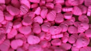 <p>Ecstasy-Tabletten in Form von Totenköpfen liegen in einem Zollamt auf einem Tisch. Die Droge gibt es auch in flüssiger Form.</p>