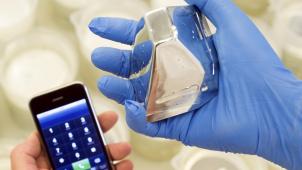 <p>Ein Stück Gallium-Metall neben einem modernen Mobiltelefon, in dem dieses Edelmetall verarbeitet wird.</p>