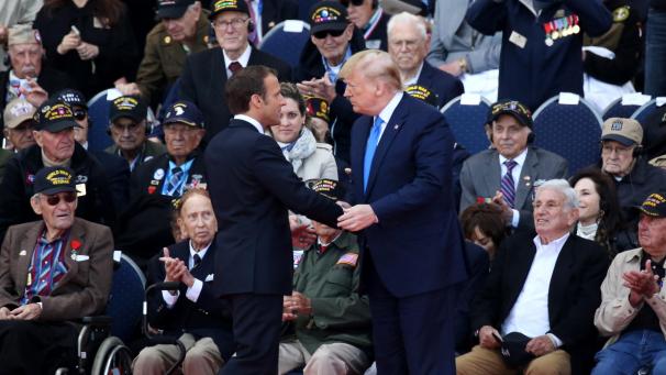 <p>Der französische Präsident Emmanuel Macron (links) und US-Präsident Donald Trump begrüßen sich bei einer Gedenkveranstaltung in Colleville-sur-Mer vor der Ehrentribüne, auf der die Kriegsveteranen Platz genommen hatten.</p>
