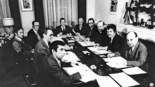 <p>Die Anfänge der Autonomie in der Deutschsprachigen Gemeinschaft Mitte der 70er Jahre: Auf dem Foto erkennt man das erste Präsidium des Rates der deutschen Kulturgemeinschaft (RdK) und die Fraktionsführer: Hinten in der Mitte ist der erste Ratspräsident Johann Weynand zu sehen, dann drehend im Uhrzeigersinn August Pitsch, Generalsekretär Manfred Beckers, Dr. Michel Louis, Lorenz Paasch, Manfred Betsch, Ferdi Dupont, Josef Fatzaun, Bernd Gentges und Albert Gehlen.</p>