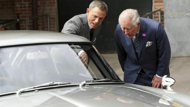 <p>Charles (r), britischer Prinz von Wales, steht mit dem Schauspieler Daniel Craig bei einem Besuch des Sets des 25. James-Bond-Films in den Pinewood Studios hinter dem Aston Martin DB5 Bond-Auto aus einem Bond-Film, während Craig spricht.</p>
