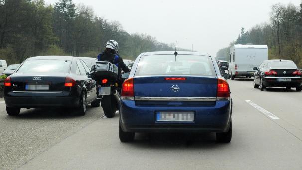 <p>Schneller zur Arbeit: Motorradfahrer schlängeln sich durch den stauenden Berufsverkehr</p>
