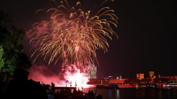 <p>Zuschauer verfolgen am Rheinufer das große Feuerwerk zur Musik von Jacques Offenbach.</p>
