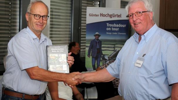 <p>Dieter Schröder (r.) überreichte Mechernichs Bürgermeister Dr. Hans-Peter Schick das erste Exemplar seines Mammutwerks „Künstlerlexikon Maler der Eifel“.</p>