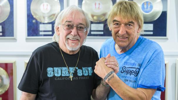 <p>Karl-Heinz Ulrich (l.) und sein Bruder Bernd im Haus von Bernd vor silbernen und goldenen Tonträgern</p>