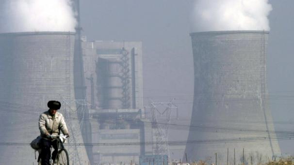 <p>Ein Chinese fährt in Shuozhou eine Straße nahe der Kühltürme des Kohlekraftwerks Shengtou entlang.</p>