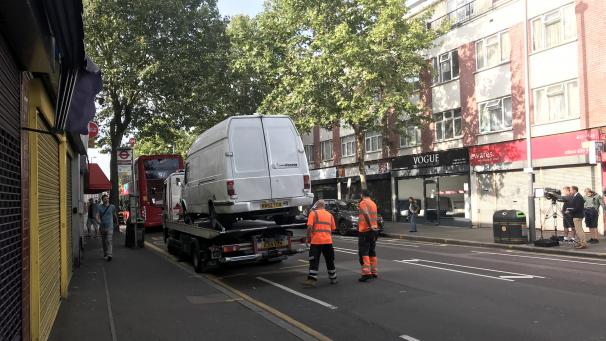 <p>Ein Lieferwagen wird von zwei Männern auf einen Autotransporter verladen. Ein Mann hat in der Nacht zuvor mit einem Messer einen Polizisten angegriffen, als dieser den Lieferwagen angehalten hatte.</p>