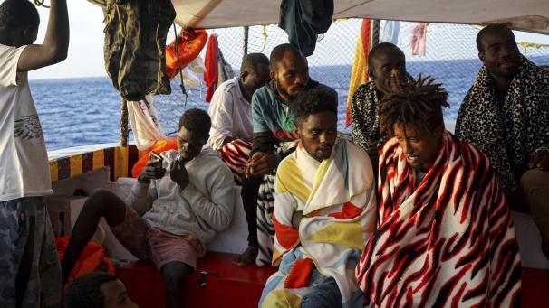<p>Migranten sitzen an Bord des Rettungsschiffes „Open Arms“</p>