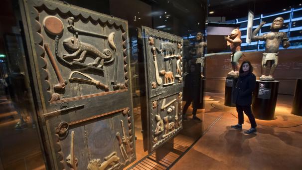 <p>Eine Besucherin geht an einer Tür aus dem 19. Jahrhundert vorbei, die aus dem Königspalast von Glele aus dem Dahomey-Königreich im heutigen Benin stammt. Frankreichs Staatschef hat 2017 die Rückgabe von Kolonialkunst versprochen. Damit hat er auch andere Länder unter Druck gesetzt. In Frankreich ist jedoch nur wenig passiert.</p>