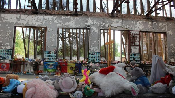 <p>Stofftiere und Blumen liegen in der Ruine der Turnhalle der alten Schule. Der Sportsaal war bei dem Terrorangriff 2004 zerstört worden.</p>