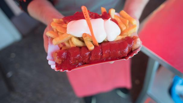 <p>Berlin: Lazo Vujinovic steht anlässlich des 70. Geburtstags der Currywurst vor Curry 36 mit einer Currywurst und Fritten.</p>