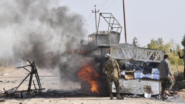 <p>Soldaten stehen nach einem möglichen Drohnenangriff in der Nähe des Grenzübergangs in der Provinz Anbar neben einem brennenden Fahrzeug. Iran-treue Milizen sagen, dass ein erneuter Drohnenangriff einen Kommandanten getötet und einen anderen bei dem Angriff verletzt hat.</p>