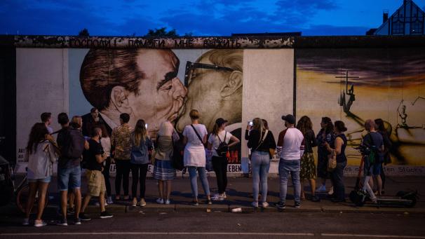 <p>Touristen und Besucher stehen vor dem sogenannten Bruderkussgemälde an der East Side Gallery. Vor fast 30 Jahren hatten sich hier Künstler verewigt und das längste noch erhaltene Teilstück der Berliner Mauer mit ihren Kunstwerken umgedeutet.</p>