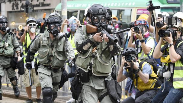 <p>Bereitschaftspolizisten zielen mit ihren Waffen während eines Protestmarschs in Hongkong.</p>