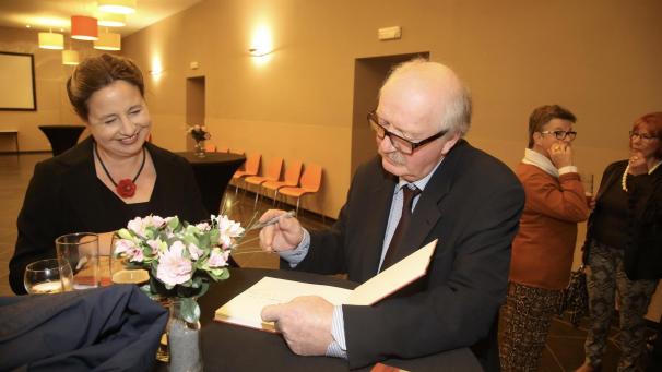 <p>André Paquet signiert sein Buch für eine Besucherin.</p>