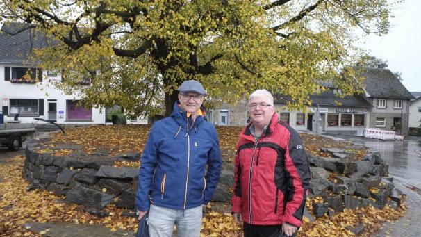 <p>Stephan Noel (l.) und Charles Servaty vor der alten Linde: Der Baum ist der Mittelpunkt des Dorfzentrums und durch eine besonders gestaltete Mauer geschützt.</p>