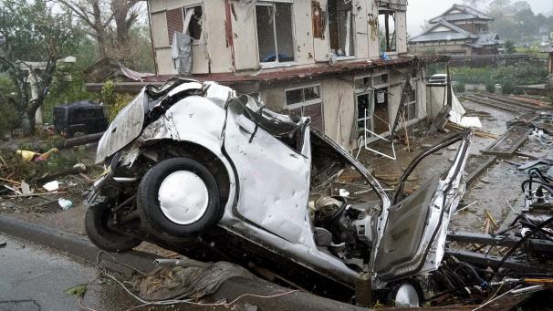 <p>Ein zerstörtes Auto liegt neben einem beschädigten Haus. In Japan hat der heftige Taifun „Hagibis“ erste Schäden angerichtet.</p>