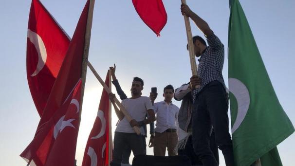 <p>Männer schwenkten türkische Nationalflaggen und feierten die Übernahme einer syrischen Provinz durch das türkische Militär.</p>