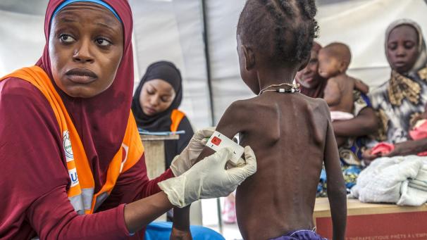 <p>Eine Frau misst den Armumfang eines Jungen in einer Nothilfeeinrichtung in Nigeria.</p>