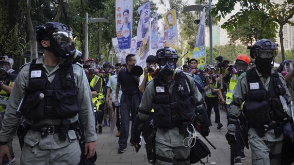 <p>Polizisten in Schutzkleidung sichern eine neue Demonstration in Hongkong.</p>