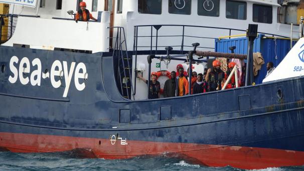 <p>Migranten und Besatzungsmitglieder stehen an Deck des deutschen Rettungsschiffs „Alan Kurdi“, während es in den Hafen von Tarent (Taranto) einläuft.</p>