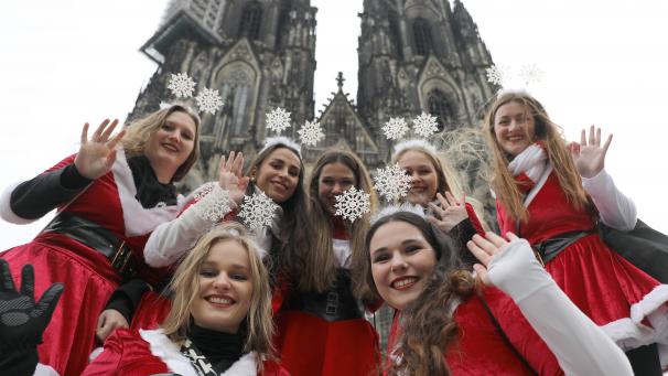 <p>Karnevalistinnen winken vor dem Kölner Dom.</p>