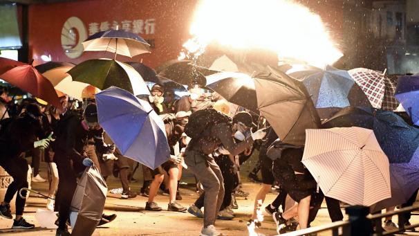 <p>Demonstranten in der Nähe der Hong Kong Polytechnic University im Bezirk Kowloon suchen Schutz hinter Regenschirmen.</p>