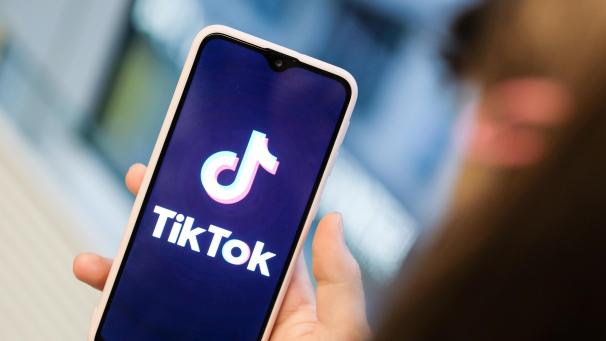 <p>Ein Mädchen hält ihr Smartphone in den Händen, auf dem sie ein Foto der Kurzvideo-App TikTok geöffnet hat. Damit können Nutzer kurze Handyvideos zu Musik oder zu anderen Videos erstellen. Andere können dazu kommentieren, Herzen verteilen oder anderweitig reagieren. Auch private Nachrichten sind möglich. Die App ist vor allem bei Jugendlichen sehr beliebt.</p>