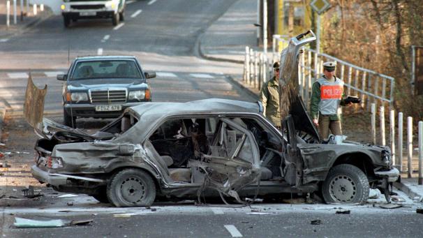 <p>Polizeibeamte in Bad Homburg neben dem Wrack der Herrhausen-Limousine.</p>