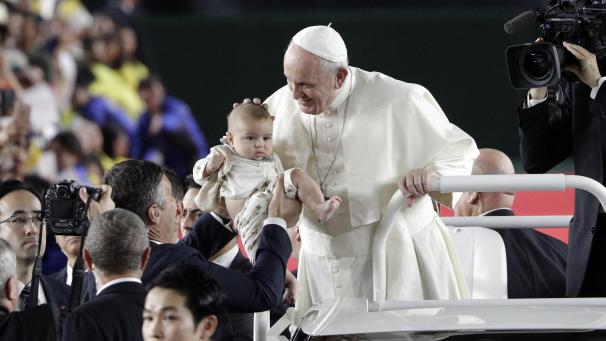 <p>Papst Franziskus steht bei seiner Ankunft im Tokyo Dome zur Heiligen Messe im Papamobil, und streichelt einem Kind über den Kopf, welches ihm entgegengestreckt wird.</p>