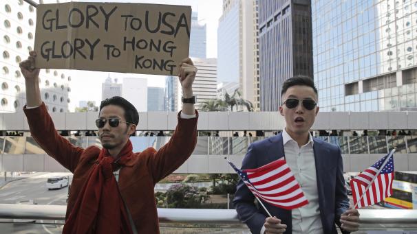 <p>Demonstranten halten amerikanische Flaggen und ein Plakat mit der Aufschrift „Glory to USA, Glory to Hong Kong“ während einer Demonstration im Central District, dem Finanzdistrikt von Hongkong.</p>