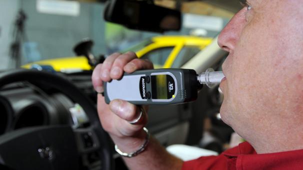 <p>Ein Autofahrer bläst in die Alkohol-Zündschlosssperre. Bei zu viel Alkohol im Blut springt der Wagen nicht an.</p>