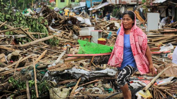 <p>Ein Bewohnerin geht an Trümmern von zerstörten Häuser vorbei, nachdem der Taifun Kammuri am 3. Dezember 2019 die Stadt Sorsogon südlich von Manila getroffen hat.</p>