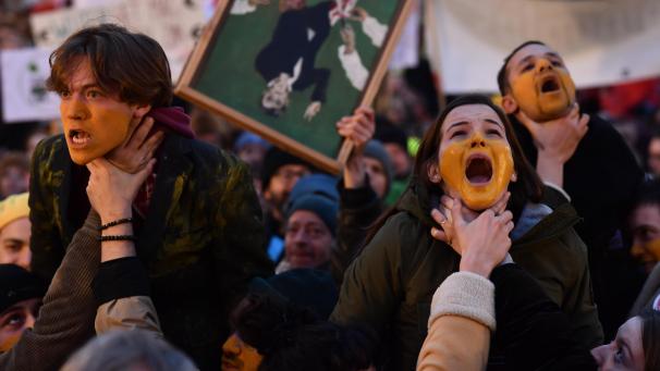 <p>Demonstranten der VRT mit fast komplett gelb angemalten Gesichtern werden „erstickt“, was symbolisch für die „Erstickung“ der Kultur stehen soll.</p>