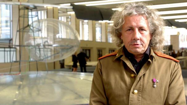 <p>Panamarenko vor einem seiner Fluggeräte anlässlich einer Ausstellung im flämischen Parlament (2004)</p>