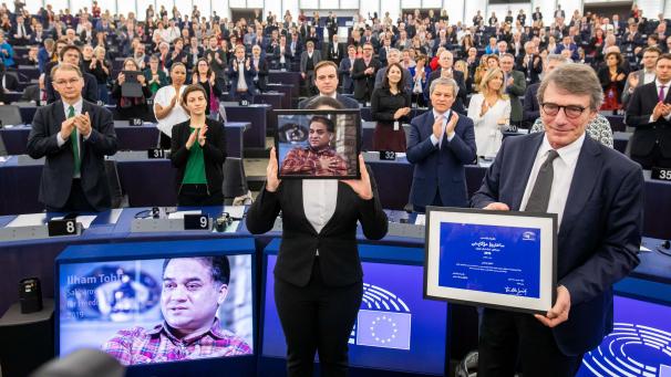 <p>Jewher Ilham (Mitte, mit verdecktem Gesicht), die Tochter des Sacharow-Preisträgers 2019, Tohti, nimmt im Namen ihres Vaters die Ehrung durch das Europäische Parlament (rechts Präsident David Sassoli) entgegen.</p>