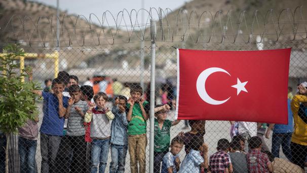 <p>Flüchtlingskinder stehen hinter einem Zaun im Nizip-Flüchtlingslager in Gaziantep.</p>