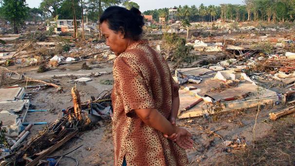 <p>Thailand, Phang Nga: Eine Frau geht durch die Trümmer des vom Tsunami am 26. Dezember 2004 zerstörten Nang Thong-Resorts am Strand von Khao Lak.</p>