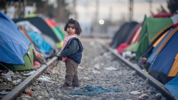 <p>Ein Kind steht im Flüchtlingslager an der Grenze zwischen Griechenland und Mazedonien.</p>