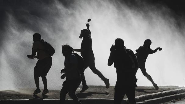 <p>Demonstranten werfen Steine auf Wasserwerfer die von der Polizei bei einem Protest gegen die Regierung zum Einsatz gebracht werden.</p>