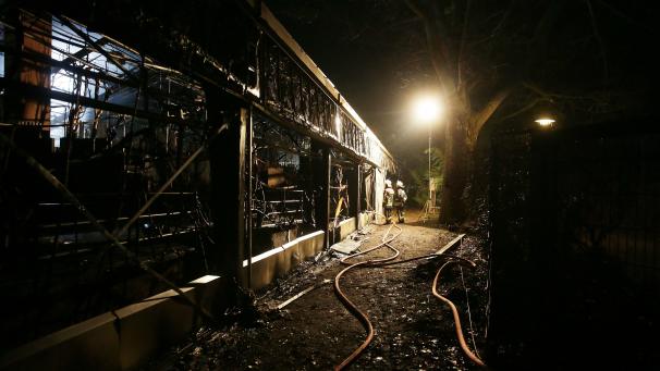 <p>Feuerwehrleute stehen nach Löscharbeiten vor dem Affenhaus des Krefelder Zoos.</p>